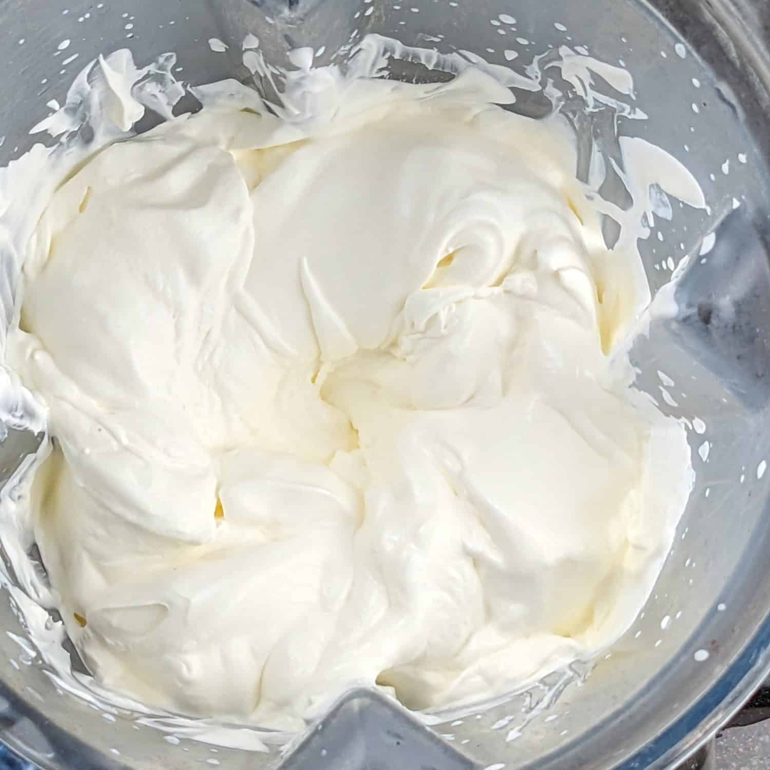 Creamy whipped cream in a blender, perfect for desserts like no-churn ice cream.
